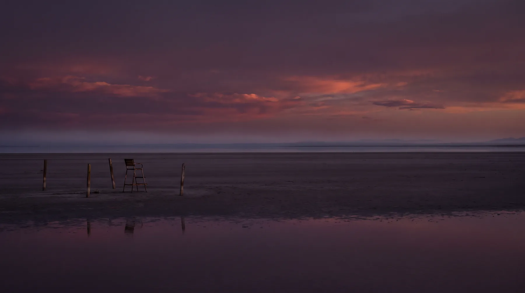 A dusk salt flat reflecting a second displaced horizon